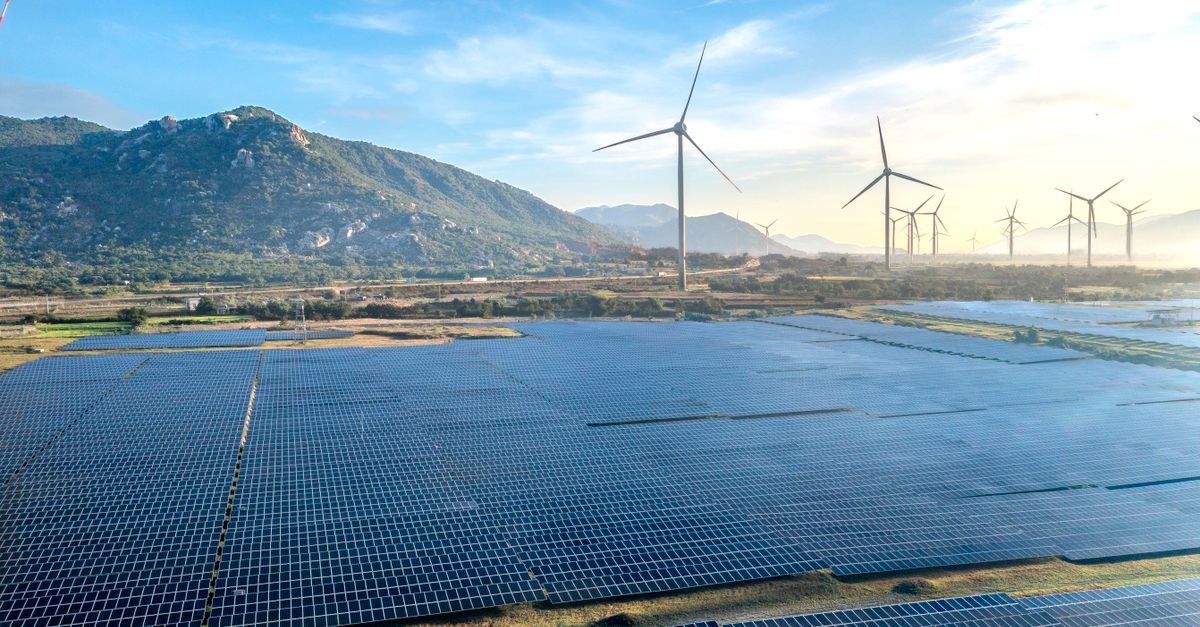 Aerial view of a solar and wind energy farm set against Vietnam's scenic landscape.